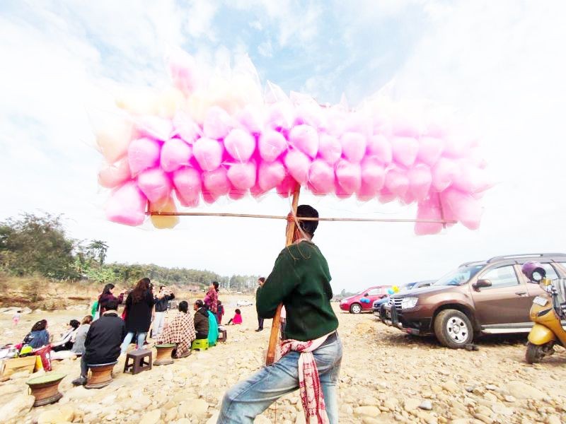 A man holding a pole of cotton candy packets for sale in Chümoukedima area. (Morung file photo)